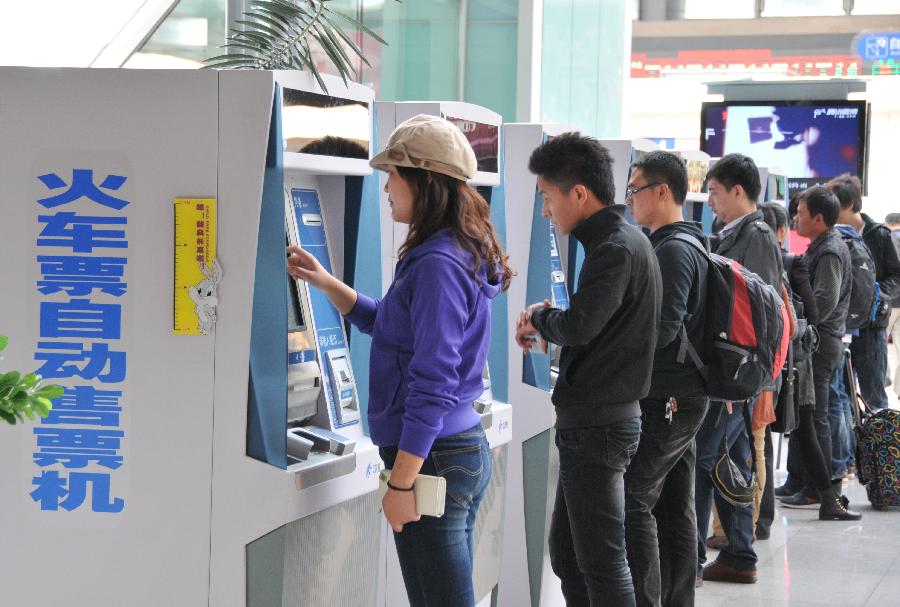 Passengers use automatic ticket machine at Beijing South Railway Station in Beijing, capital of China, Sept. 30, 2011. According to the Ministry of Railways, tickets of all the direct express trains would be sold online since this Sunday and tickets of special express trains would be sold online since Dec. 10 this year. [Li Chaozhen/Xinhua]