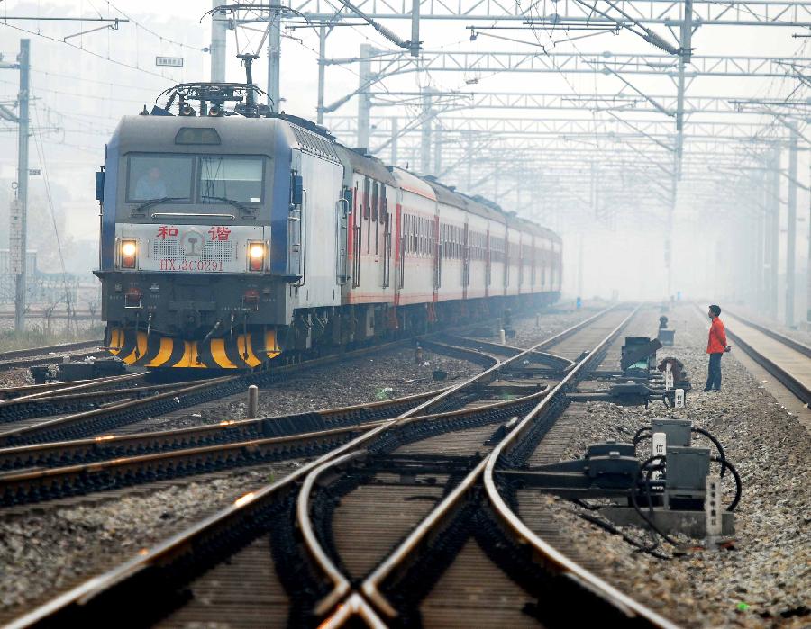 A train runs on the Jiujiang section of Beijing-Kowloon (Jingjiu) Railway in Jiujiang, east China's Jiangxi Province, Nov. 18, 2011. According to the Ministry of Railways, tickets of all the direct express trains would be sold online since this Sunday and tickets of special express trains would be sold online since Dec. 10 this year. [Hu Guolin/Xinhua]