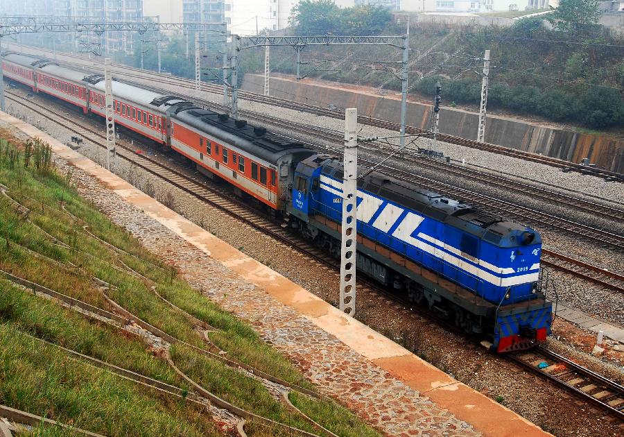 A train runs on the Jiujiang section of Beijing-Kowloon (Jingjiu) Railway in Jiujiang, east China's Jiangxi Province, Nov. 18, 2011. According to the Ministry of Railways, tickets of all the direct express trains would be sold online since this Sunday and tickets of special express trains would be sold online since Dec. 10 this year. [Hu Guolin/Xinhua]