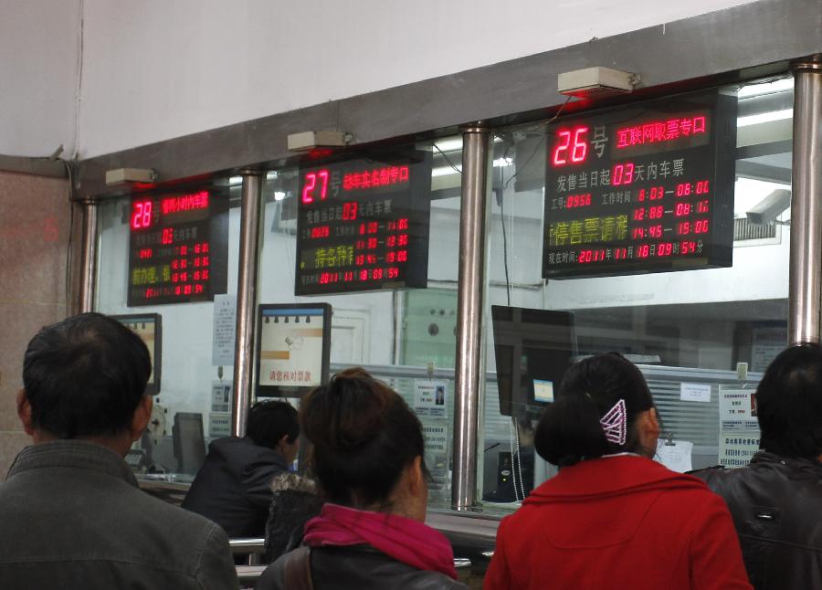 Passengers pick up tickets they bought online at Xi'an Railway Station in Xi'an, capital of northwest China's Shaanxi Province, Nov. 18, 2011. According to the Ministry of Railways, tickets of all the direct express trains would be sold online since this Sunday and tickets of special express trains would be sold online since Dec. 10 this year. [Jiao Hongtao/Xinhua]