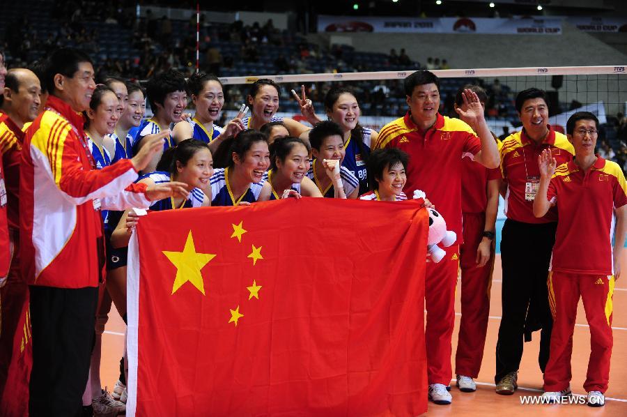 Members of Chinese women's volleyball team pose for photos after beating Germany at the World Cup women's volleyball tournament in Tokyo, Japan, on Nov. 18, 2011. China beat Germany 3-0 here in their last match of the event and secured a London 2012 Olympic Games ticket, with the third ranking on the final World Cup Standing. [Ji Chunpeng/Xinhua]