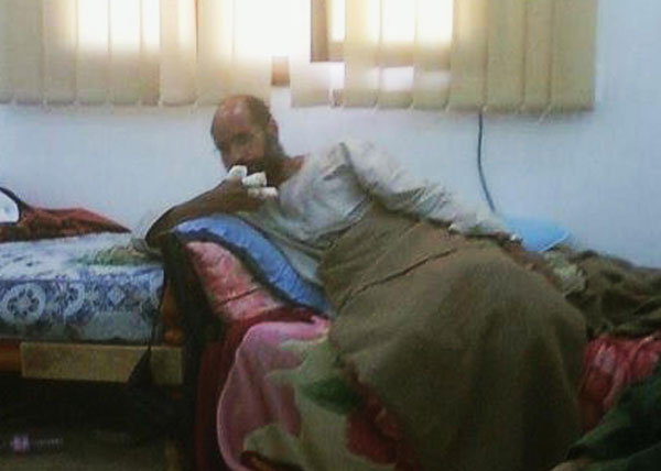 Saif al-Islam, son of the late former Libyan leader Muammar Gaddafi, sits after his capture, with his fingers wrapped in bandages and his legs covered with a blanket, at an undisclosed location, in this photograph aired on Free Libya TV on November 19, 2011. [China Daily] 