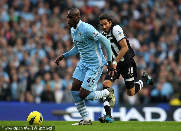 Mario Balotelli of Manchester City competes with Jonas Gutierrez of Newcastle United during the Barclays Premier League match between Manchester City and Newcastle United at the City of Manchester Stadium on November 19, 2011 in Manchester, England. 