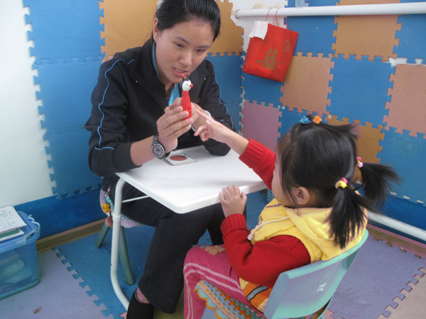 Teacher Liu Lini works on language with Le Le, a 3-year-old girl with autism, at Qingdao Shengzhiai Rehabilitation Center. Each Lesson last about 20 minutes. [Photo/China Daily]