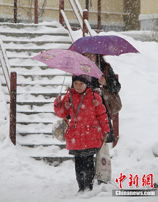 People walk in the snow in Altay, Xinjiang Uygur Autonomous Region on November 20, 2011. Heavy snowfalls also severely impact agricultural production of the region. 