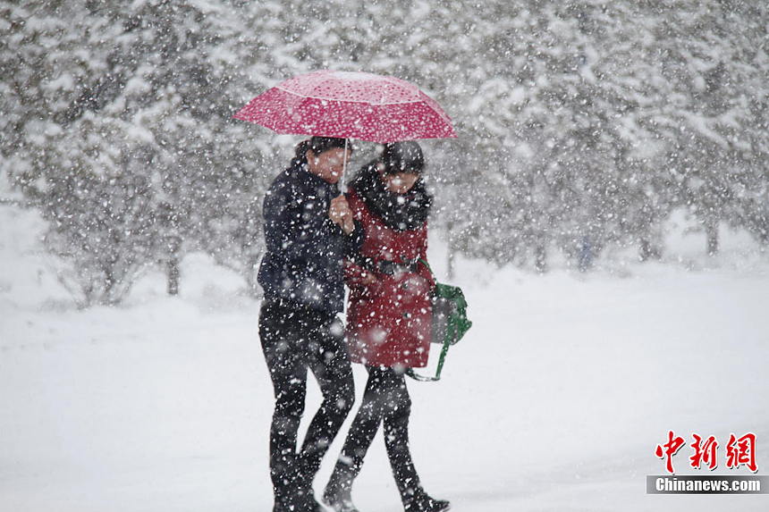 People walk in the snow in Altay, Xinjiang Uygur Autonomous Region on November 20, 2011. Heavy snowfalls also severely impact agricultural production of the region. 