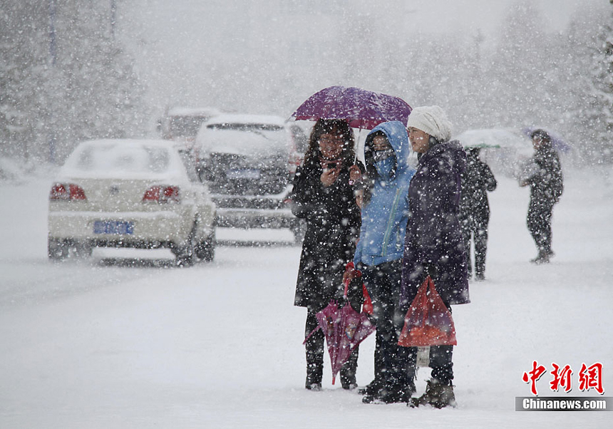 People walk in the snow in Altay, Xinjiang Uygur Autonomous Region on November 20, 2011. Heavy snowfalls also severely impact agricultural production of the region. 