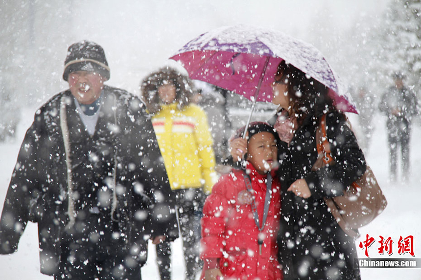 People walk in the snow in Altay, Xinjiang Uygur Autonomous Region on November 20, 2011. Heavy snowfalls also severely impact agricultural production of the region. 