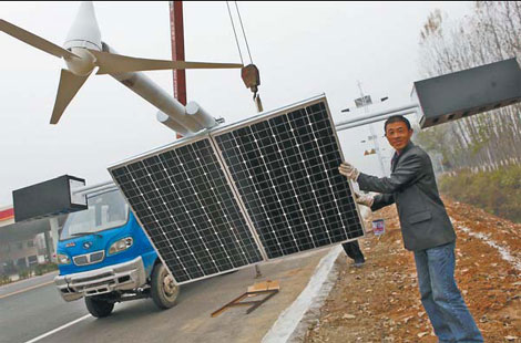 A worker recently sets up a wind/solar hybrid streetlight in Xiangcheng county, Henan province.[China Daily] 