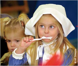 Dressed as a Pilgrim, a young girl enjoys a forkful of mashed potatoes at the Montessori Children's Center in Wheeling, West Virginia. [IIP Digital]