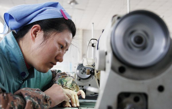 An employee works at a sewing-machine at a garment factory in Huaibei, Anhui Province. [CFP] 