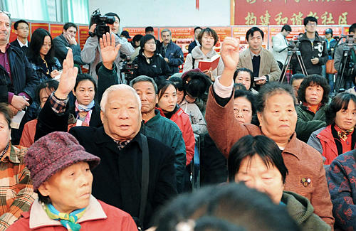 Voters in the Bajiao No.3 Constituency raise hands to ask candidates questions at a meeting on November 2 [By Li Wen/Beijing Review] 