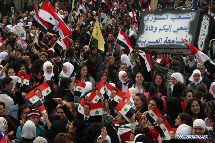Syrians carry a small coffin with an Arabic writings 'The Syrian people mourns the death of the Arab League' during a rally held by thousands of Syrian women in the district of Bab Touma in Damascus, Syria, on Nov. 24, 2011. 