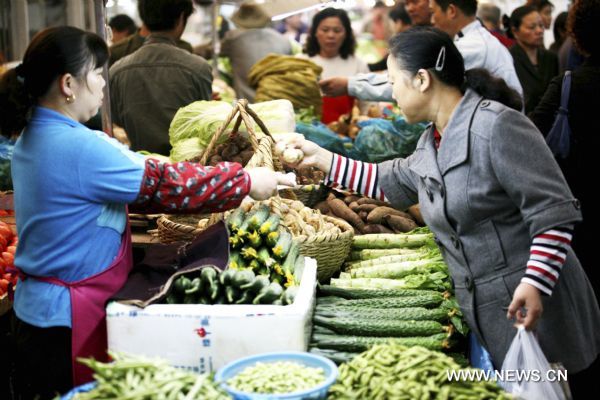 Consumers select vegetables at a market in Nanjing, capital city of east China's Jiangsu Province, Oct. 14, 2011.