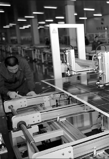 A factory worker at Solargiga Energy Holdings Ltd, a Jinzhou-based solar-cell company, selects solar panels. 