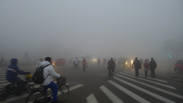 People cycle through dense fog in the port city of Tianjin in North China, Nov 28, 2011. The fog piled up since midnight on Monday and as of 8 am, all flights were delayed and most of the expressways toll stations are closed because of the heavy fog. [Xinhua] 