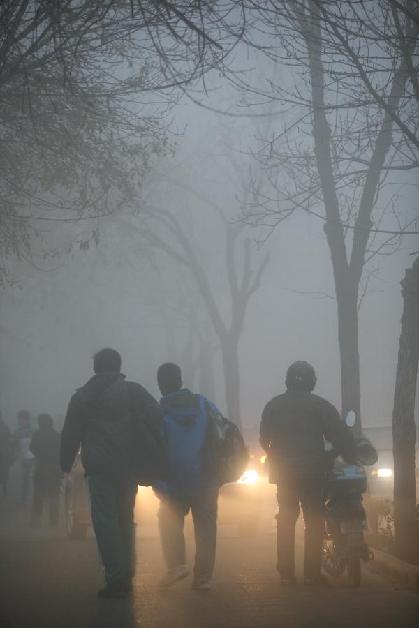 Citizens travel in the fog-shrouded Tianjin, north China, Nov. 28, 2011. 