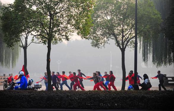  Citizens do morning exercises in the fog-shrouded Yangzhou, east China's Jiangsu Province, Nov. 28, 2011. 