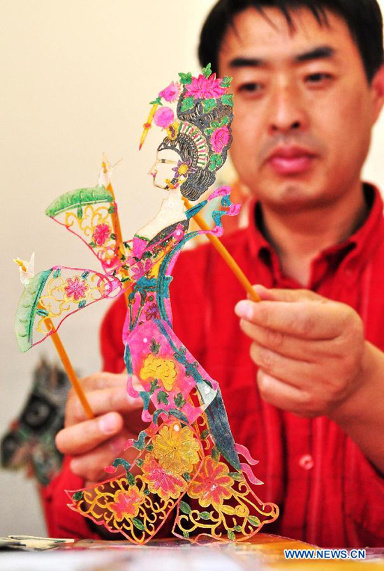 An artist manipulates the puppetry for shadow puppetry performance in Nanning, capital of south China's Guangxi Zhuang Autonomous Region, Nov. 2, 2011. 