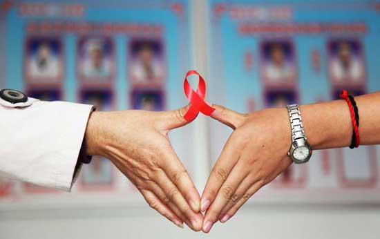 A volunteer and a HIV infected person set up a heart-shaped gesture holding a red banner in Hengyang, central China's Hunan Province, Nov. 29, 2011. Falling on Dec. 1, the World AIDS Day has its theme of 'Getting to Zero' this year. [Xinhua]