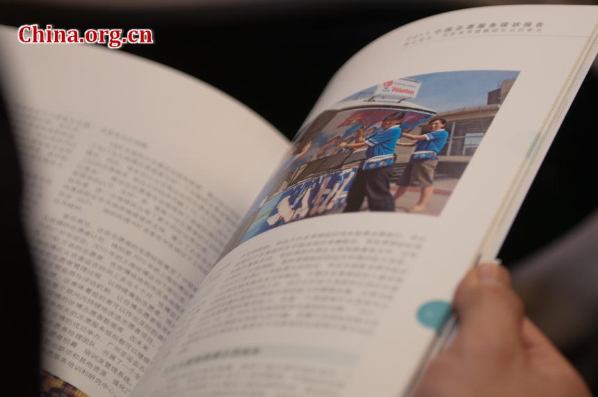 An attendant at the 30 Years of UNV in China celebration browses the brochure that briefs the UNV&apos;s work over the past three decades. [Pierre Chen / China.org.cn]