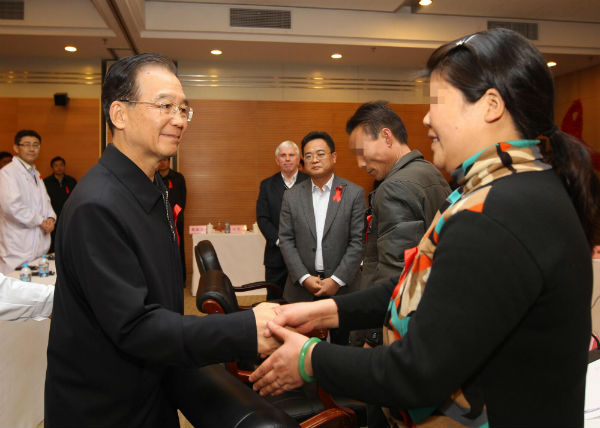 Chinese Premier Wen Jiabao shakes hands with an HIV carrier during a discussion with a group of people representing HIV carriers and AIDS patients, doctors and AIDS researchers in Beijing, on Dec 1, 2011. [Photo/Xinhua]    