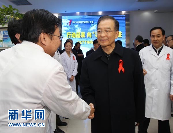 Chinese Premier Wen Jiabao (R, Front) shakes hands with a doctor at the Chinese Center for Disease Control and Prevention (CCDCP) in Beijing, capital of China, Dec. 1, 2011. 