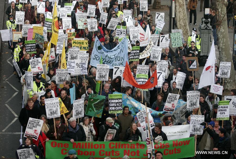 Protestors march during a climate change demonstration in central London, Britain, Dec. 3, 2011. Hundreds of environmentalists marched in central London to protest that 7% of the world's richest population produce 50% of the world's carbon emissions. 