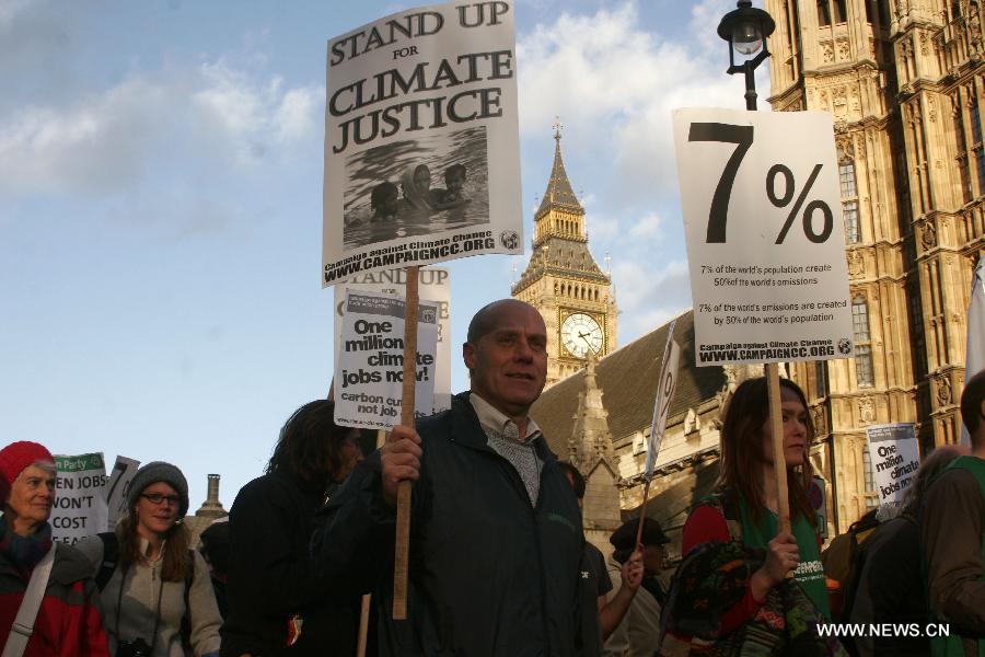 Protestors march during a climate change demonstration in central London, Britain, Dec. 3, 2011. 