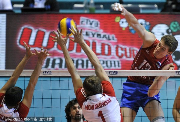 Dmitriy Muserskiy (R) of Russia spikes the ball against Piotr Nowakowski (C) and Michal Winiarski (L) of Poland during the fourth round match of the FIVB Men's Volleyball World Cup 2011 in Tokyo, Japan, 04 December 2011. Russia captured 2011 FIVB Men's World Cup title by beating Poland in final match. 