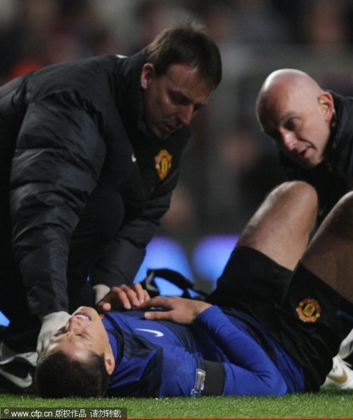 Javier 'Chicharito' Hernandez of Manchester United receives treatment on an ankle injury from Dr Steve McNally (L) and physio Rob Swire during the Barclays Premier League match between Aston Villa and Manchester United at Villa Park on December 3, 2011 in Birmingham, England.