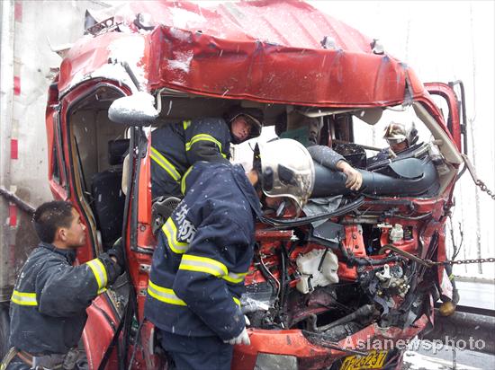 Rescurers carry an injured after a mass pile up involving more than 50 vehicles on the Weifang section of Qingdao-Jinan highway in Shandong province, Dec 8, 2011. [Photo/Asianewsphoto] 