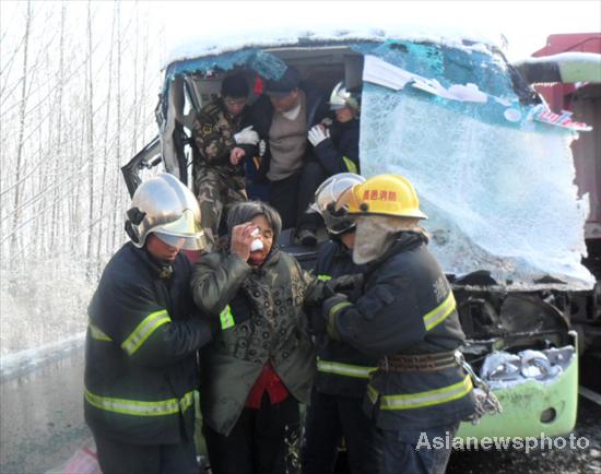 Rescurers carry an injured passenger on the Weifang section of Qingdao-Jinan highway in Shandong province, Dec 8, 2011. [Photo/Asianewsphoto]