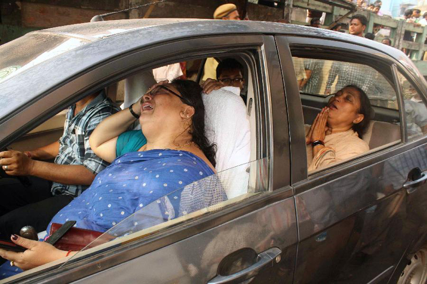 Relatives of a victim in AMRI hospital fire in India are overwhelmed by grief, Dec. 9, 2011. Medical staff fled as flames and smoke filled an Indian hospital in the eastern Indian city of Kolkata early Friday, abandoning their patients to a fire that killed 89 people. Police arrested six hospital officials on charges of culpable homicide. 