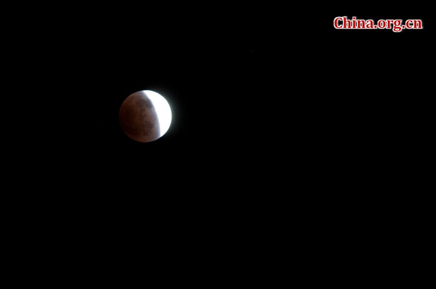 The indirect sunlight can still illuminate the Moon, putting it into a dramatic shade of red. [Pierre Chen / China.org.cn]