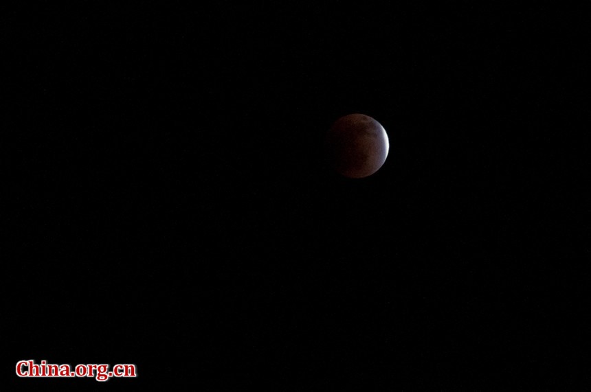 The indirect sunlight can still illuminate the Moon, putting it into a dramatic shade of red. [Pierre Chen / China.org.cn]