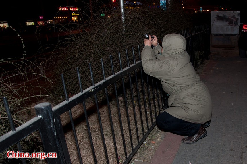 A middle aged man in Beijing trys to film the celestial event with his Panasonic camera. [Pierre Chen / China.org.cn]