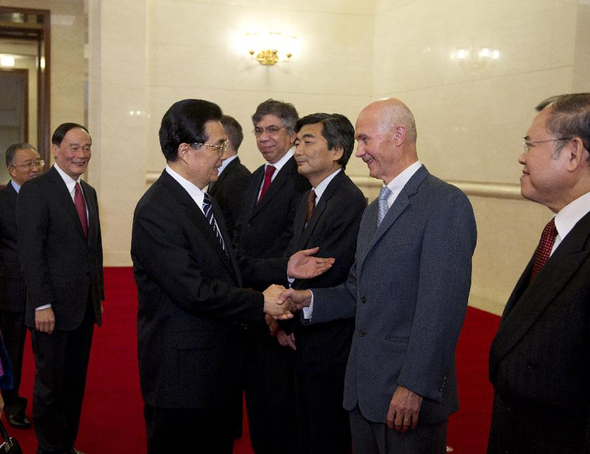 Chinese President Hu Jintao (L, front) shakes hands with Director-General of the World Trade Organization (WTO) Pascal Lamy (2nd R) before the start of the high level forum on the 10th anniversary of China's accession to the WTO in Beijing, capital of China, Dec. 11, 2011.