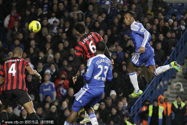 Chelsea's Didier Drogba (right) heads the ball pass Manchester City's Joleon Lescott and Vincent Kompany (left) during their English Premier League soccer match at Stamford Bridge on Monday, Dec. 12, 2011.