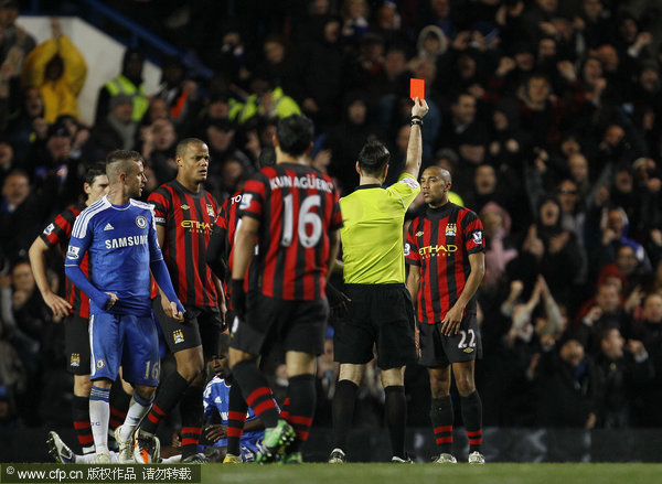 Manchester City's Gael Clichy (right) is sent off by referee Mark Clattenburg for a foul on Chelsea's Didier Drogba during their English Premier League soccer match at Chelsea's Stamford Bridge stadium in London on Monday, Dec. 12, 2011.