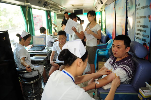 A man donates blood in a mobile blood donation station in Liaocheng, East China's Shandong province, on World Blood Donor Day, June 14,2011.[Photo/CFP] 