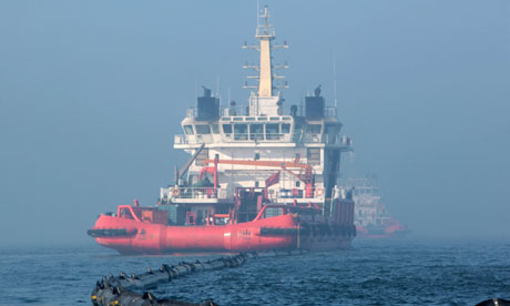 A ship cleans up the leaking oil near the platform C in the Bohai Sea, China.[CFP]  