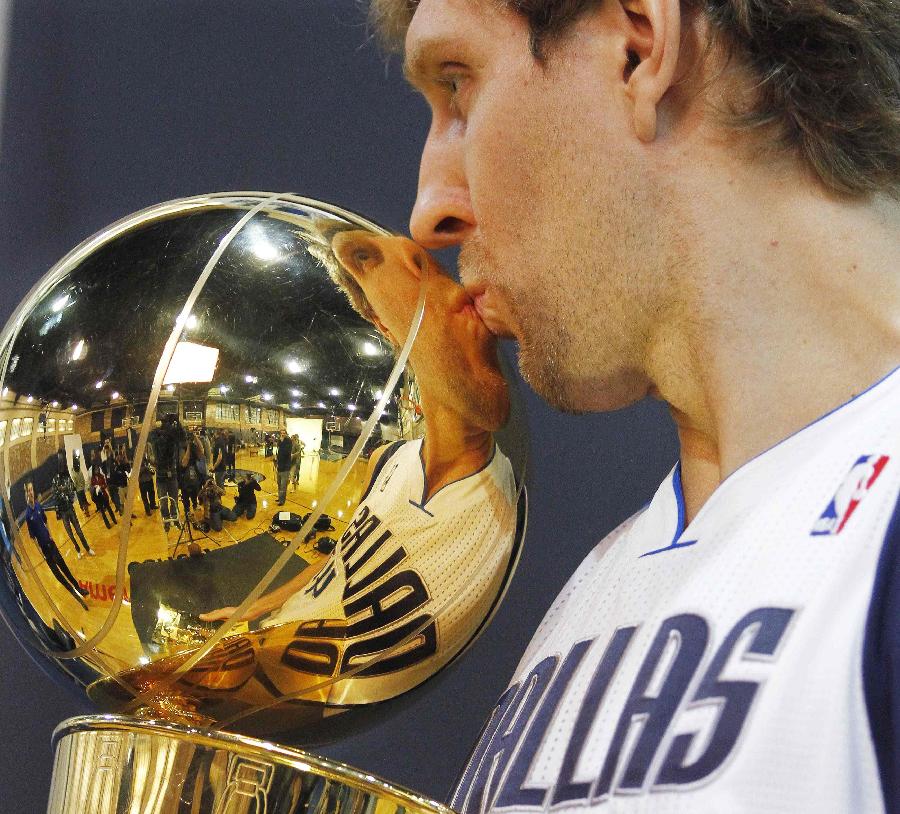 Dallas Mavericks Dirk Nowitzki, of Germany, kisses the NBA championship basketball trophy during a photo shoot at NBA basketball media day in Dallas, Tuesday, Dec. 13, 2011. (Xinhua/Reuters Photo)