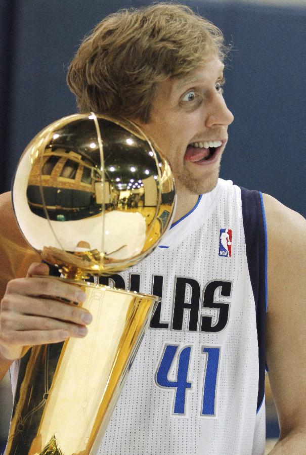 Dallas Mavericks forward Dirk Nowitzki makes a face for photographers with the NBA Larry O'Brien Championship Trophy during media day at the team's headquarters in Dallas, Texas December 13, 2011. (Xinhua/Reuters Photo)