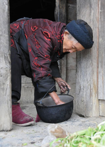 Jin Jifen, 106, prepares to cook a meal at home, Dec 6, 2011. 'I can't live without working,' she said. [Photo/Xinhua] 