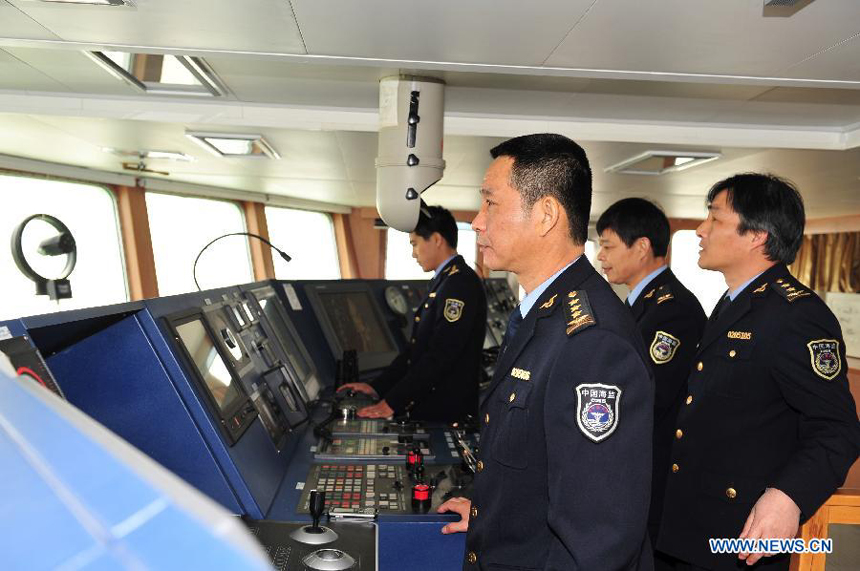 Guo Yizhong (front), deputy chief of the 5th Detachment of China Marine Surveillance, works at the navigation bridge of the 'China Haijian 50', Dec. 13, 2011. The most advanced vessel of China Marine Surveillance, 'Haijian 50', set off from Shanghai Port of the State Oceanic Administration Tuesday for its maiden voyage.