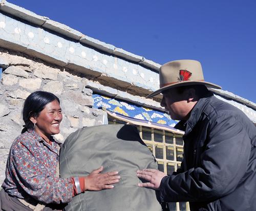 China has allocated 6.3 billion yuan in funds for the country's disaster-stricken areas to buy winter relief materials. In this picture taken on December 5, 2011, Gao Baoping (R), an official from the Gaize County, Tibet Autonomous Region, sends winter relief materials to a local resident.