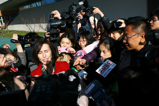 Kim Lee (center), the wife of Li Yang (right), founder of a famous English-language education institution in China, talks to reporters after the couple's divorce hearing at a Beijing court on Thursday. [China Daily] 中国知名英语教育机构的创始人李阳（右）的妻子李金（中）周四在北京一家法院出席离婚案庭审后，接受记者的采访。[中国日报]