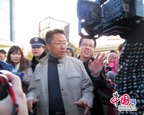 Li Yang (center) talks to reporters after the couple's divorce hearing at a Beijing court on Thursday. [China.org.cn] 李阳（中）周四在北京一家法院出席离婚案庭审后，接受记者的采访。[中国网]