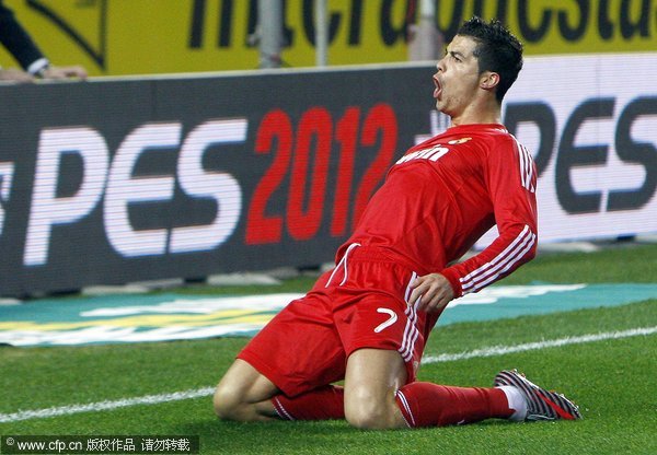 Real Madrid's Portuguese forward Cristiano Ronaldo celebrates after scoring the opening goal against Sevilla FC during the Spanish Primera Division soccer match at Sanchez Pizjuan stadium in Seville, Andalusia, southern Spain, 17 December 2011. 